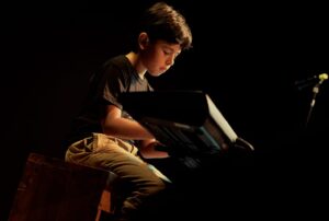 Niño llamado Isaac practicando piano en sus clases virtuales de música